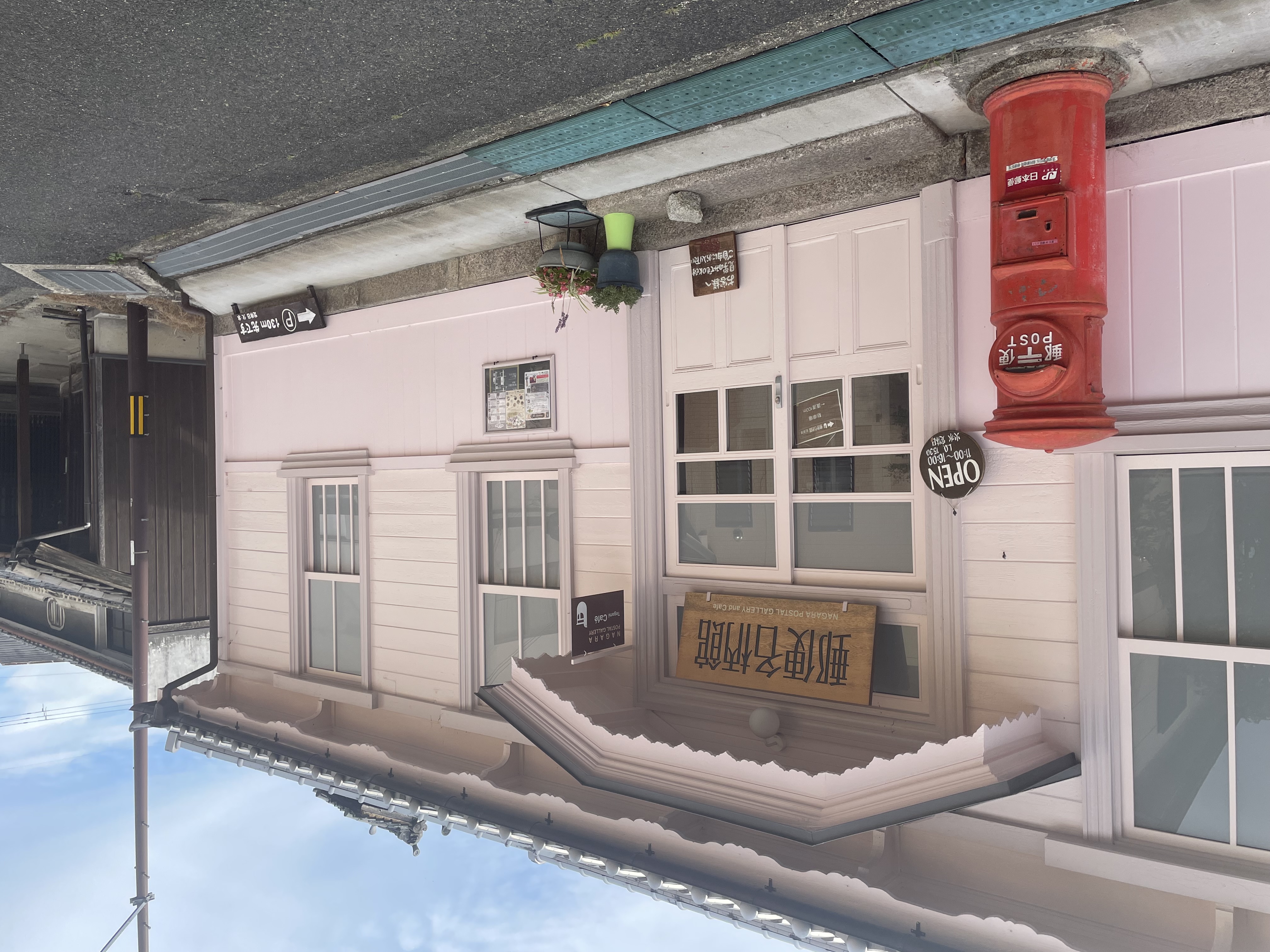 桜色の外壁と丸型ポストが印象的な入り口